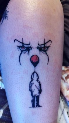 a person with a tattoo on their leg that has an evil clown's face