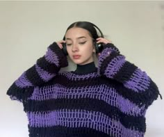 a woman with headphones wearing a purple and black sweater