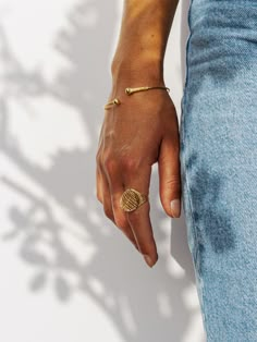 a close up of a person's hand with a gold ring on their finger