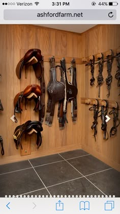 there are many different types of horse saddles on the wall and in the corner