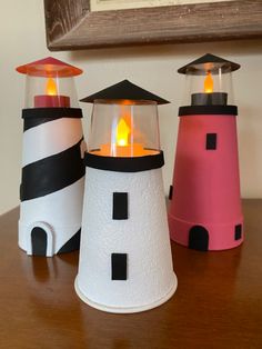 three small lighthouses sitting on top of a wooden table