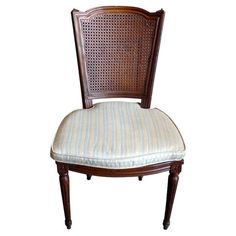 a wooden chair with a striped seat pad on it's backrest and arm rest