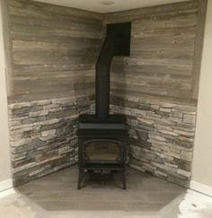 a wood burning stove in a room with stone walls and flooring on the side