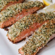 salmon fillets with herbs and lemon on a white plate