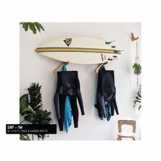 two surfboards and gloves hanging on the wall