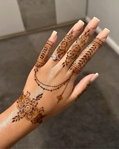 a woman's hand with henna tattoos on it