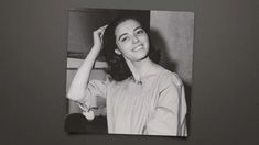 a black and white photo of a woman holding her hair