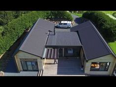 an aerial view of a house with cars parked in the driveway