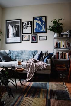 a living room filled with lots of furniture and pictures on the wall above it's couch