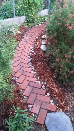 a brick path in the middle of a garden