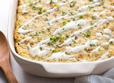 a casserole dish with white sauce and green onions