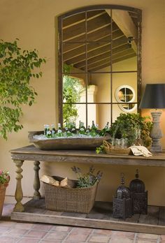 a table that has some plants on it and a mirror in the corner behind it