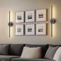 a living room with gray couches and pictures on the wall above them, along with a coffee table