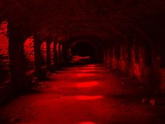 a dark tunnel with red light at the end