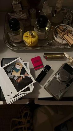 the table is cluttered with various items such as photos, pens and lipstick on it