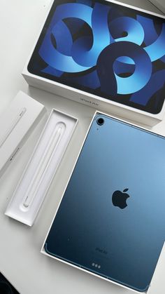 an apple ipad is sitting next to its box and other accessories on a table top