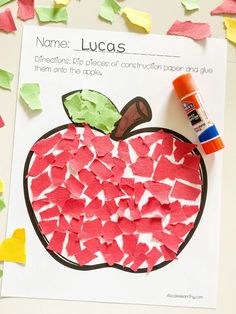 a paper plate with an apple cut out on it and glue sitting next to it