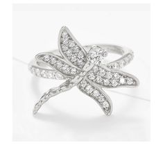 a white gold and diamond ring with a dragonfly design on the center, surrounded by smaller diamonds