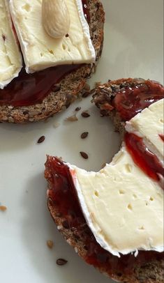 an open faced sandwich with cheese and jam on it, sitting on a white plate