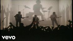 a group of people standing on top of a stage with guitars in front of them