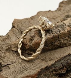 a gold ring sitting on top of a piece of wood