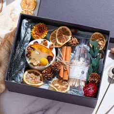 a box filled with oranges, cinnamons and other food on top of a table