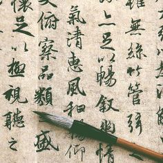 an ink pen sitting on top of a piece of paper with chinese characters written in cursive writing