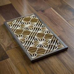 a wooden box that is on top of a wood floor with an intricate design in the middle