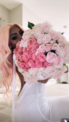 a woman with long pink hair holding a bouquet of flowers in front of her face