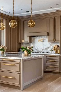 [CommissionsEarned]  Save For Later  Tap To See All 61  Taupe Kitchen Cabinets | Ready To Add Luxe Touches To Your Space? This Taupe And Gold Kitchen Design Brings Elegant Glamour Home. Save This Golden Accent Inspiration For A Luxurious Kitchen Makeover. #kitchencabinetsmakeover Glamour Kitchen Decor, Gold Accented Kitchen, Grey And Gold Kitchen Cabinets, Bronze Handles Kitchen Cabinets, Beige And White Kitchen Ideas, Brown And Gold Kitchen, Gray And Gold Kitchen, Kitchen Trends 2025 Interior Design, Two Color Kitchen