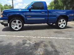 a blue pickup truck parked in a parking lot