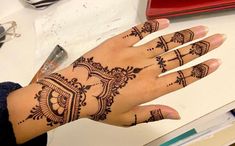 a woman's hand with henna tattoos on it