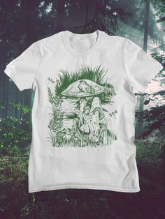 Fairycore and goblincore shirt with mushroom, frog, fairy and dragonfly in a fairytale landscape. - Gildan t shirt - Classic fit - 100 %cotton - Machine wash and dryer safe - Cold wash inside out, low heat tumble dryer Unisex SIZING Chart: Small: Length 28" - Width 18" (4-6) Medium: Length 29" - Width 20" (6-10) Large: Length 30" - Width 22" (10-14) X2XL: Length 32" - Width 26" (18-20) 3XL: Length 33" - Width 28" (20-22) All measurements are approximations. Shirts may be within 1" of the dimensi Fairy Core Shirts, Goblincore Shirt, Fairytale Landscape, Frog Fairy, Fairycore Clothing, Clothing Cottagecore, Male Fairy, Mushroom Frog, Fairy Shirt