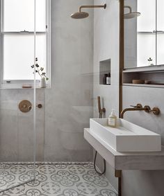 a bathroom with a sink, mirror and shower