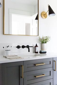 a bathroom sink with a mirror above it and a vase on the counter next to it