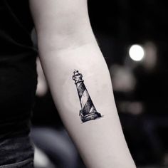 a small lighthouse tattoo on the arm