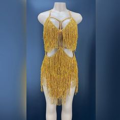 a mannequin wearing a yellow fringed dress