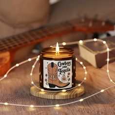 a candle that is sitting on top of a table next to a string of lights