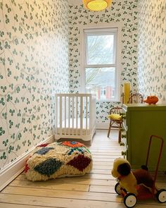 a child's room with green and white wallpaper