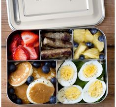 a bento box filled with breakfast foods and fruit