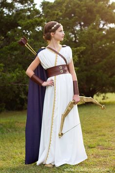 a woman dressed in roman costume holding a bow and arrow