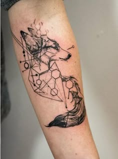 a tattoo on the leg of a person with a wolf and geometric shapes in black ink