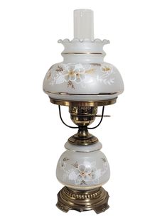 a white and gold lamp with flowers painted on the top, sitting on a stand