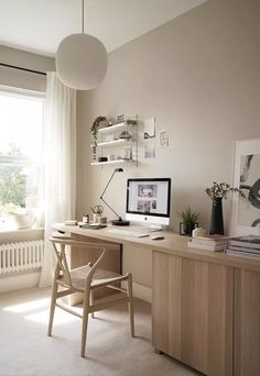 a desk with a computer on top of it next to a window