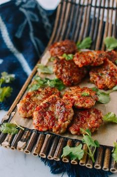 meatballs with sauce and herbs on a bamboo serving tray, ready to be eaten