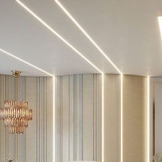 an elegant bathroom with white and gold fixtures, striped wallpaper and chandelier