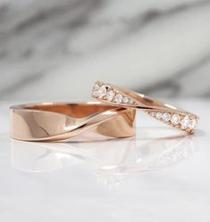 two gold wedding bands with diamonds on them