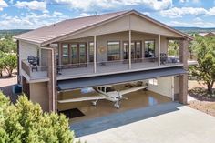 an airplane is parked in front of a house with a porch on the second floor