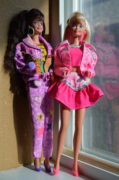 two barbie dolls are standing next to each other in front of a window sill