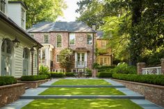 a large brick house surrounded by lush green grass